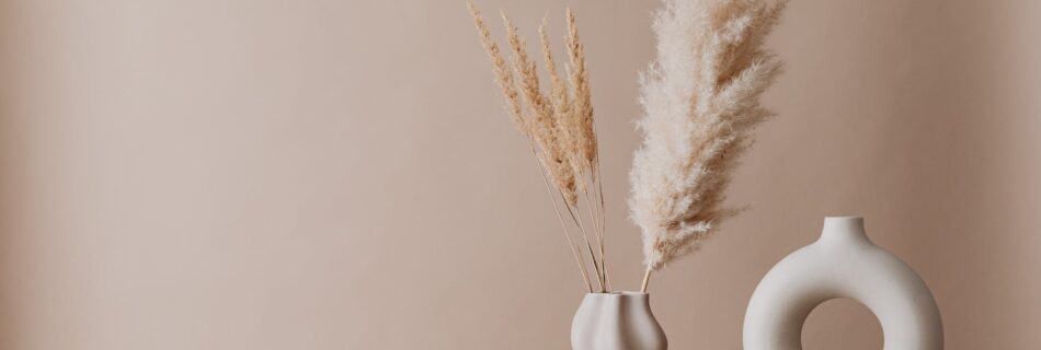 beige minimalistic decor dry grass in a vase candle and books